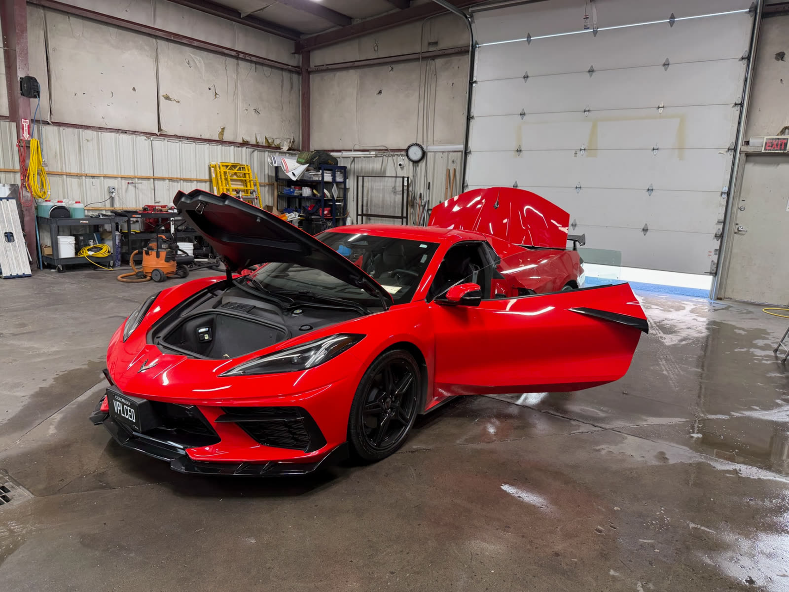 Red Corvette in the shop after a full detail, panels and trunk open
